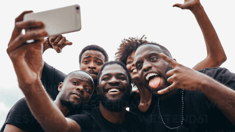 Photo of a group of Black individuals taking a selfie.