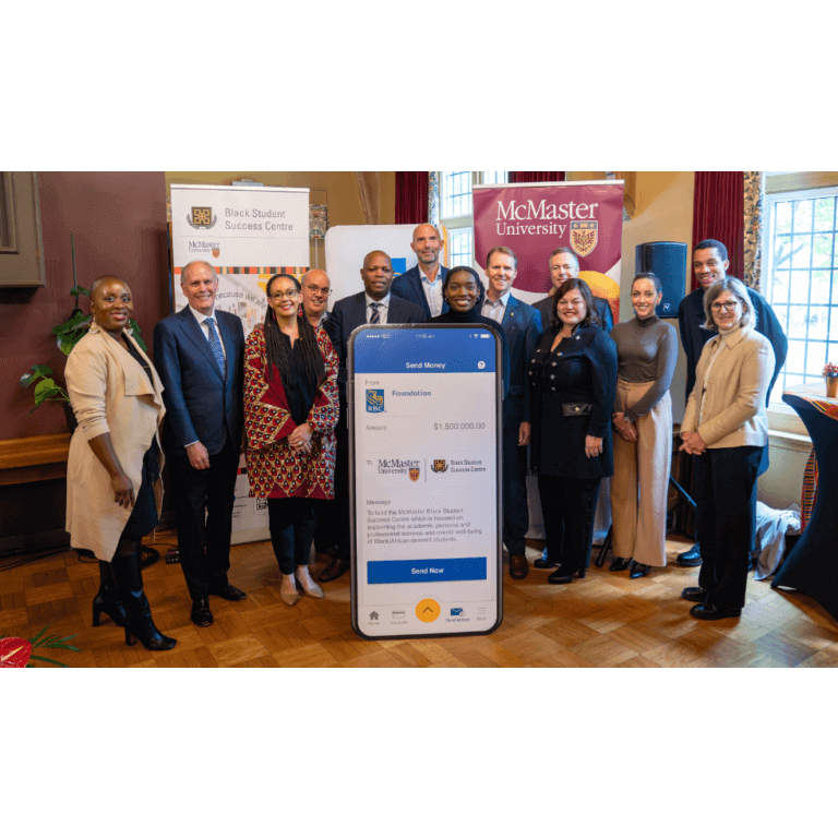 A group poses with a large mock-up of a smartphone screen displaying a donation to McMaster University Black Student Success Centre.