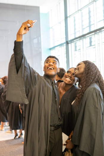 An image of graduates taking a selfie.