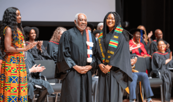 An image of Dr. Gary Warner and a graduate on stage during the Black Graduation Celebration.